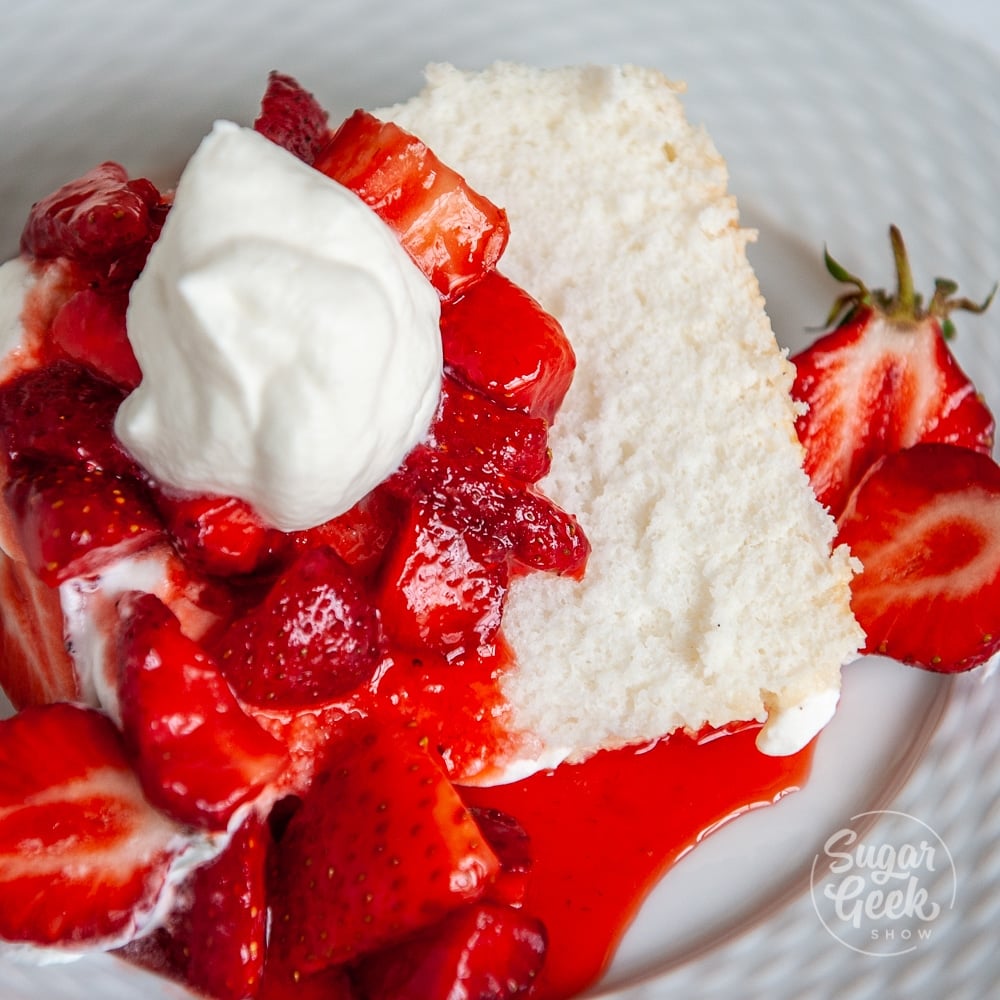 closeup of angel food cake with strawberries and whipped cream