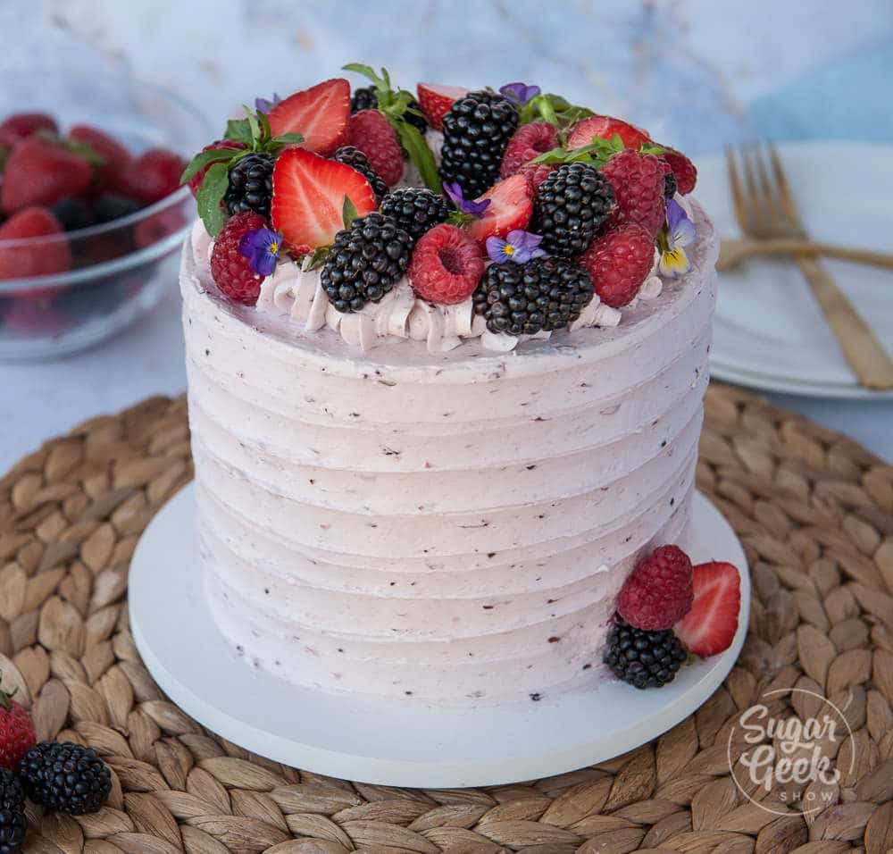 berry cake with berry buttercream and fresh berries on top