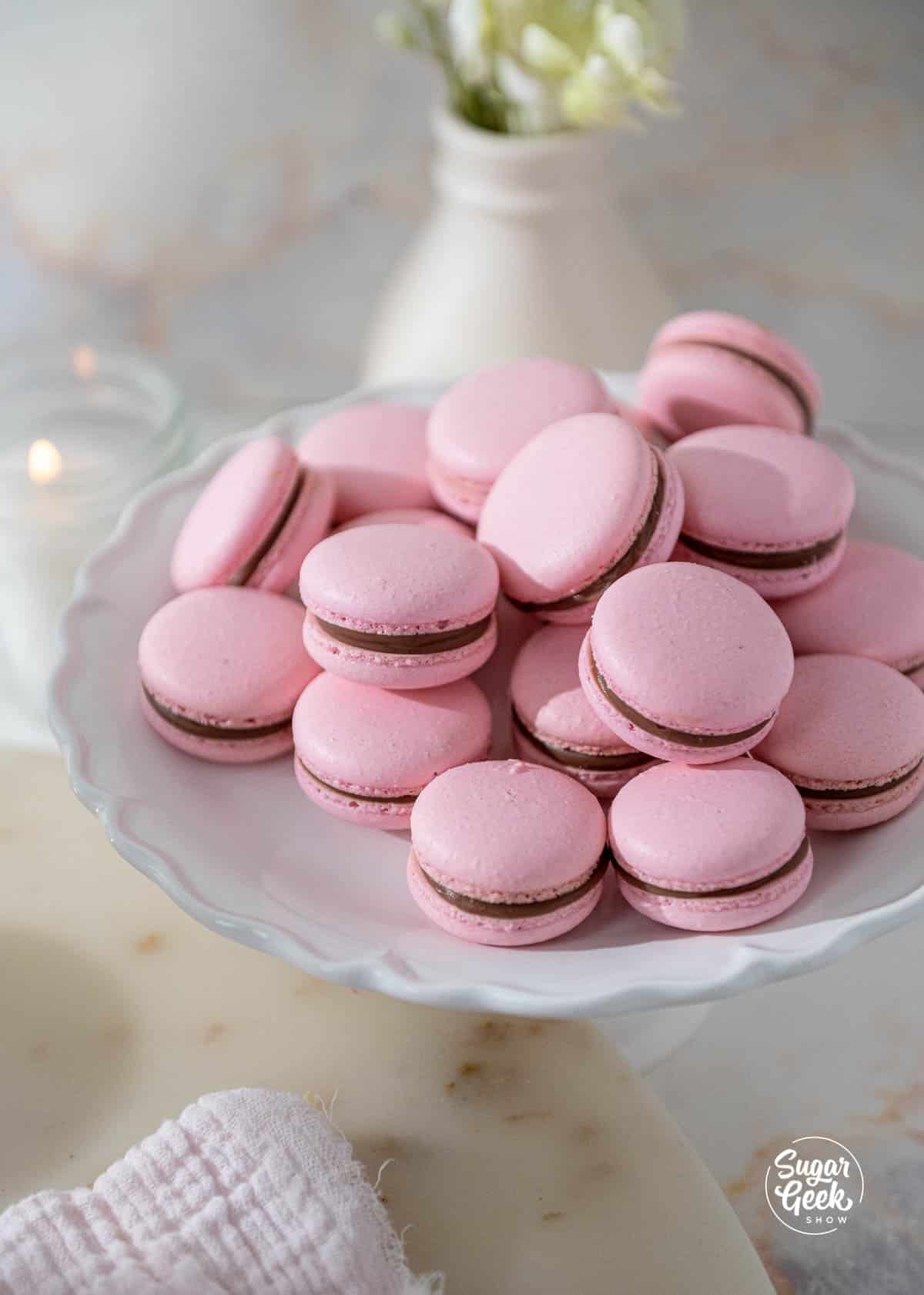 plat of pink italian macarons on a white plate