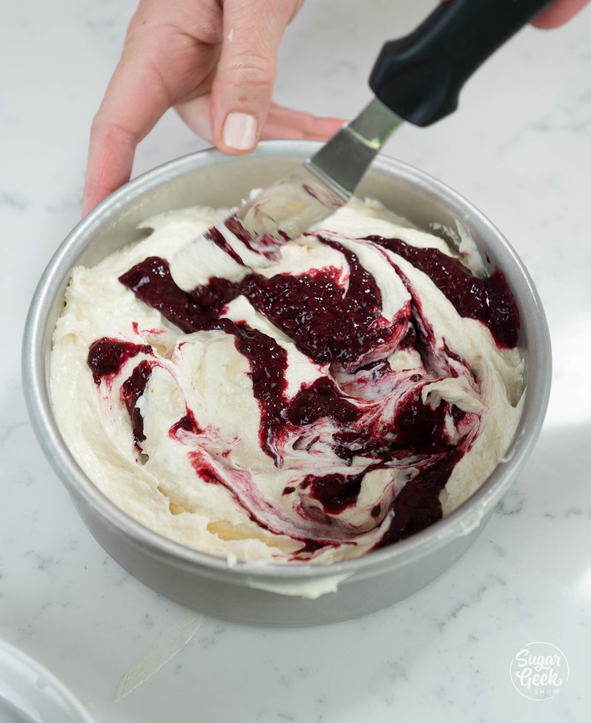 swirling blackberry puree into cake batter in pans