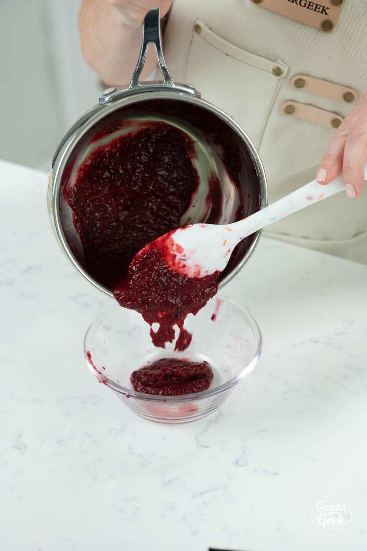 pouring blackberry puree into a glass bowl