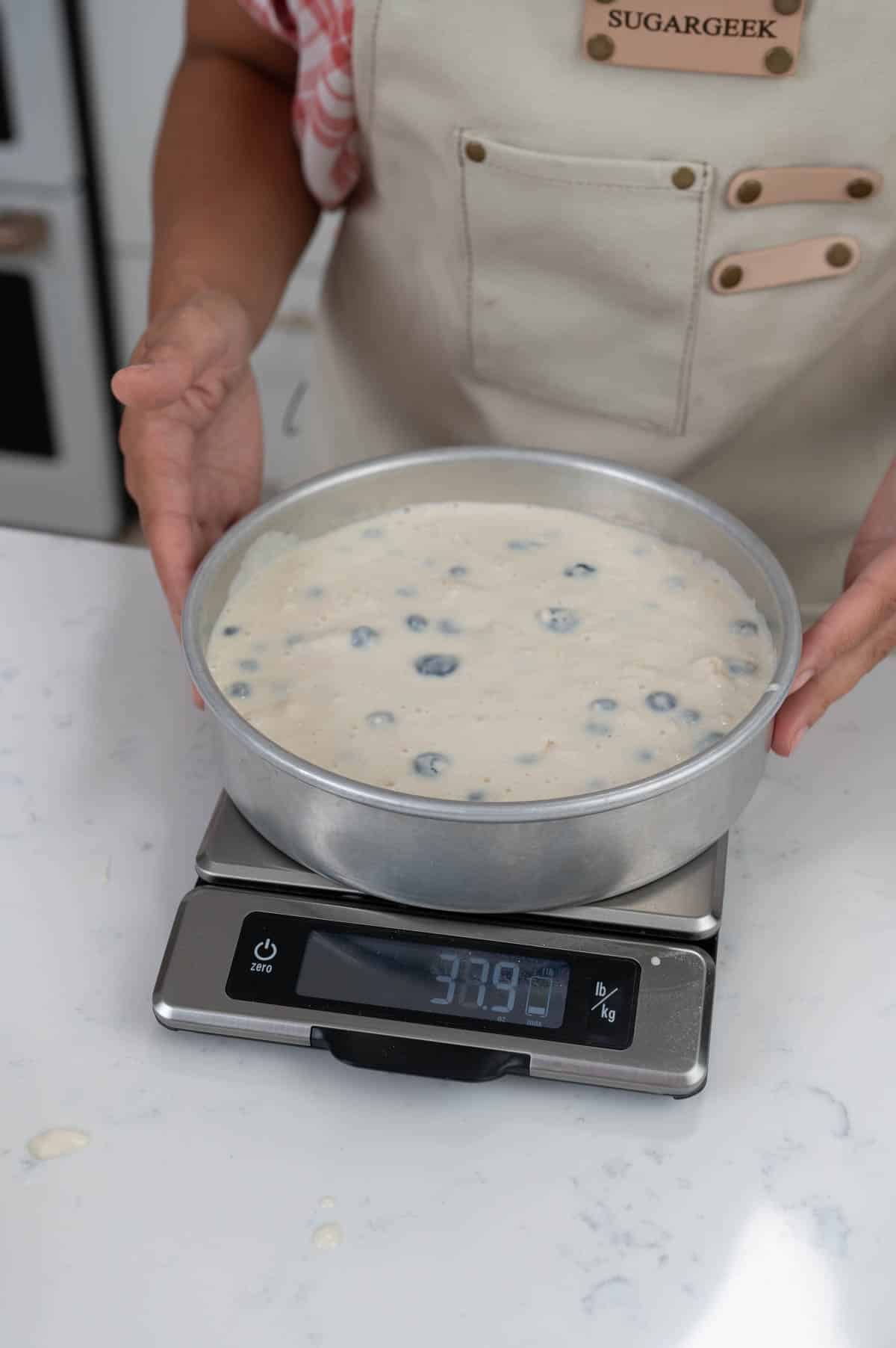 weighing a pan of cake batter on a food scale