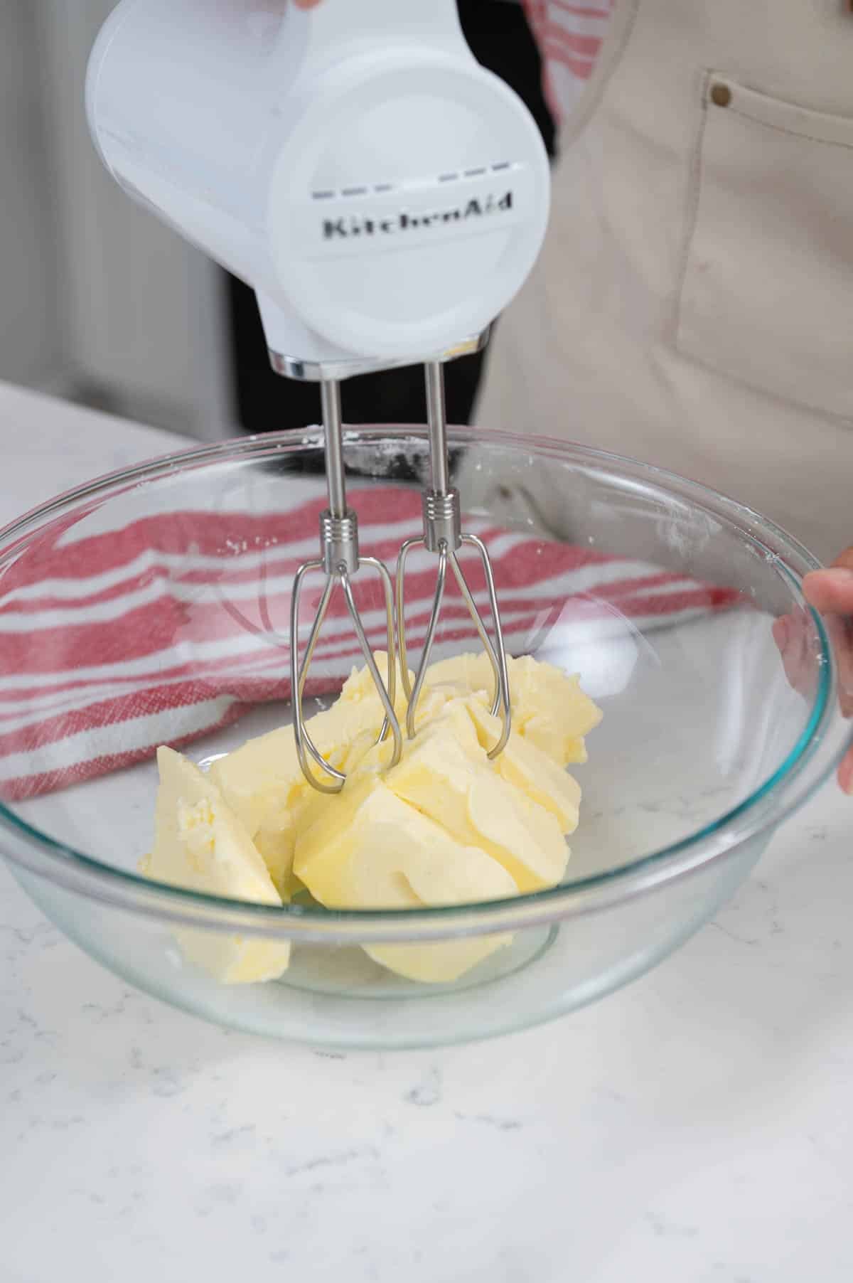 mixing butter in a large bowl with an electric mixer