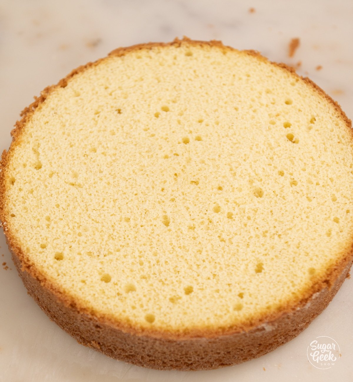 picture of a finished yellow cake layer with the top trimmed.