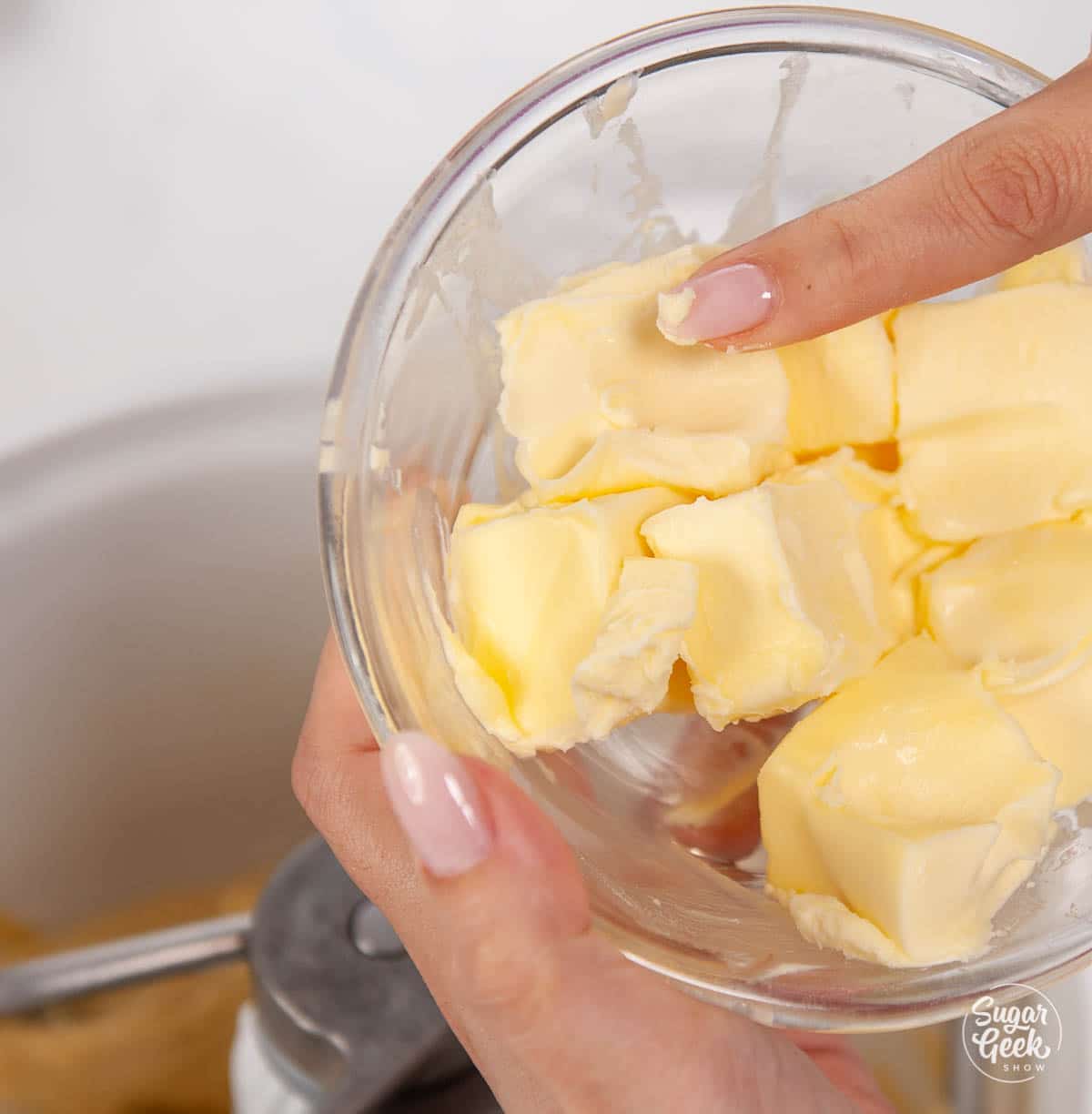closeup of finger pressing softened butter