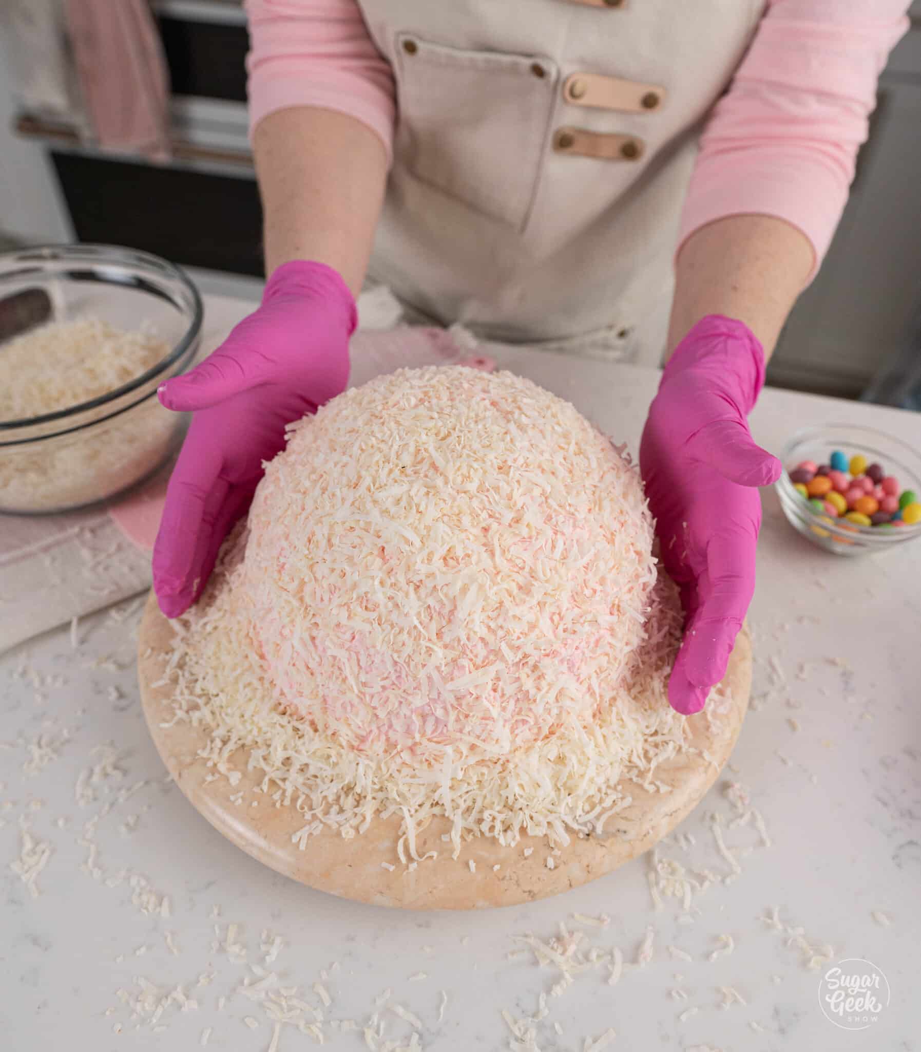 covering a dome cake in coconut