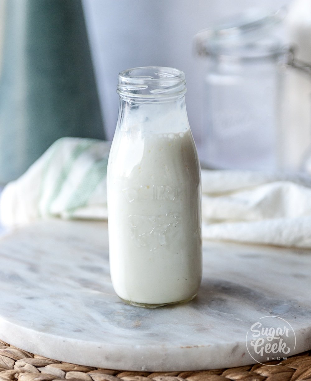 buttermilk in a clear milk jar on white background