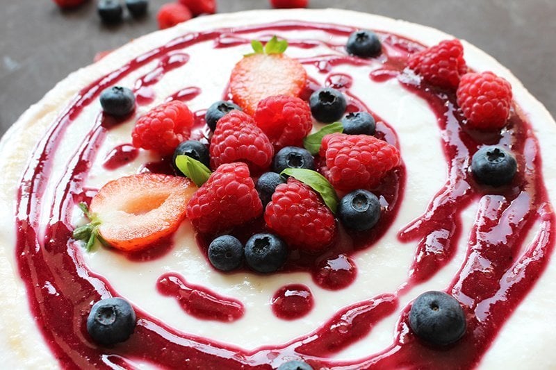 strawberry puree on cheesecake with fresh berries