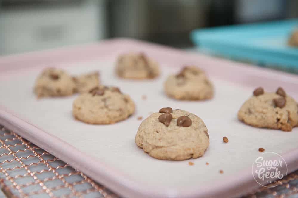 chocolate chip cookies with too much flour on a pink baking sheet