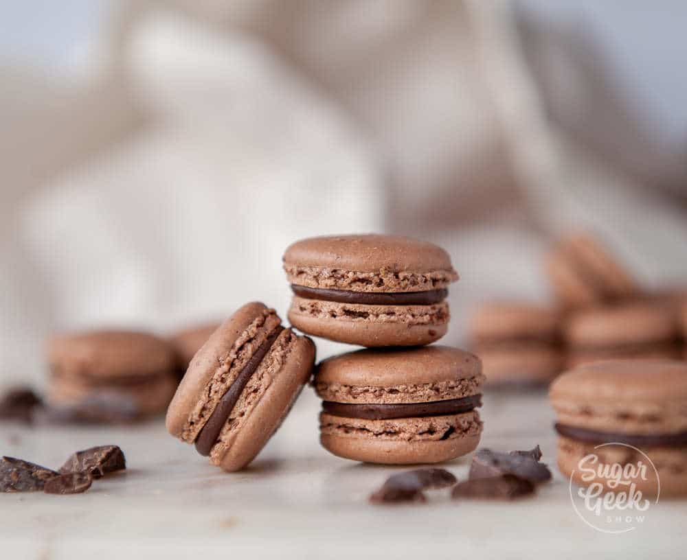 close up of three chocolate macarons with ganache filling