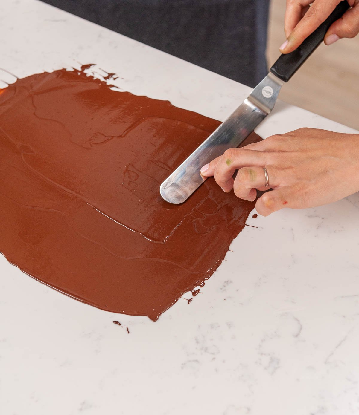 spreading chocolate on acetate with an offset spatula