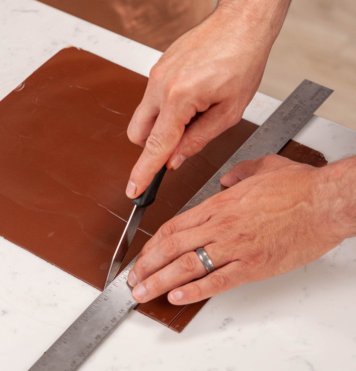cutting chocolate squares on acetate with a knife and ruler