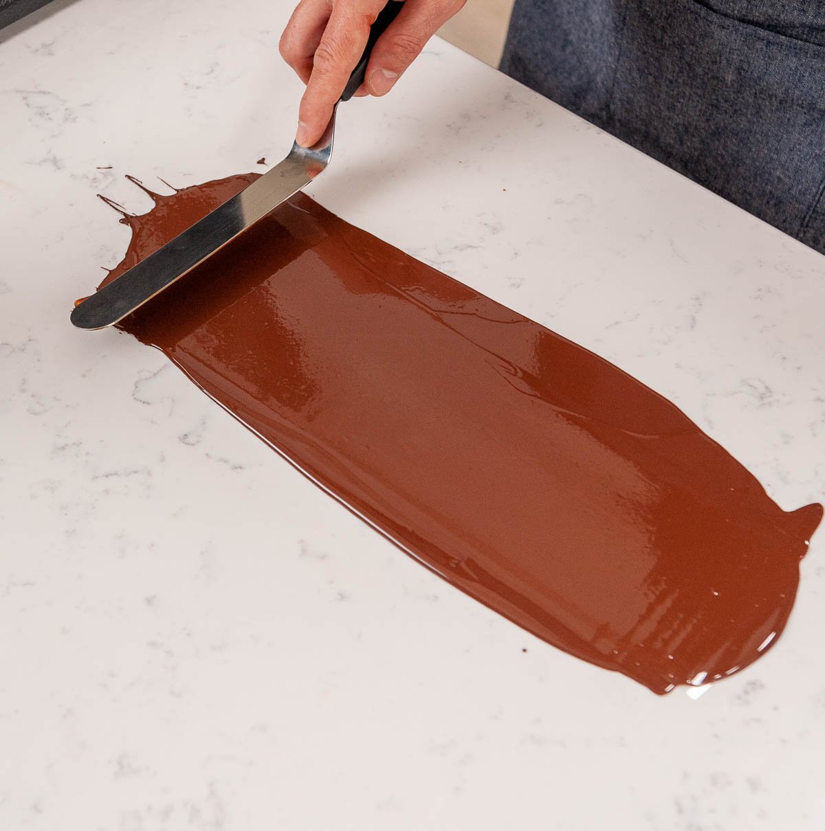 spreading tempered chocolate on acetate with an offset spatula