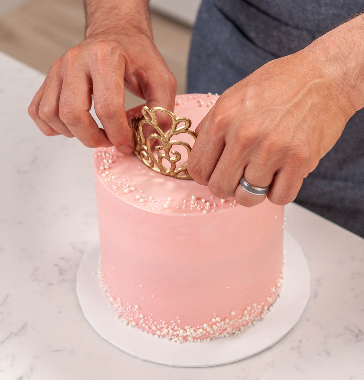 placing a chocolate tiara on top of the cake
