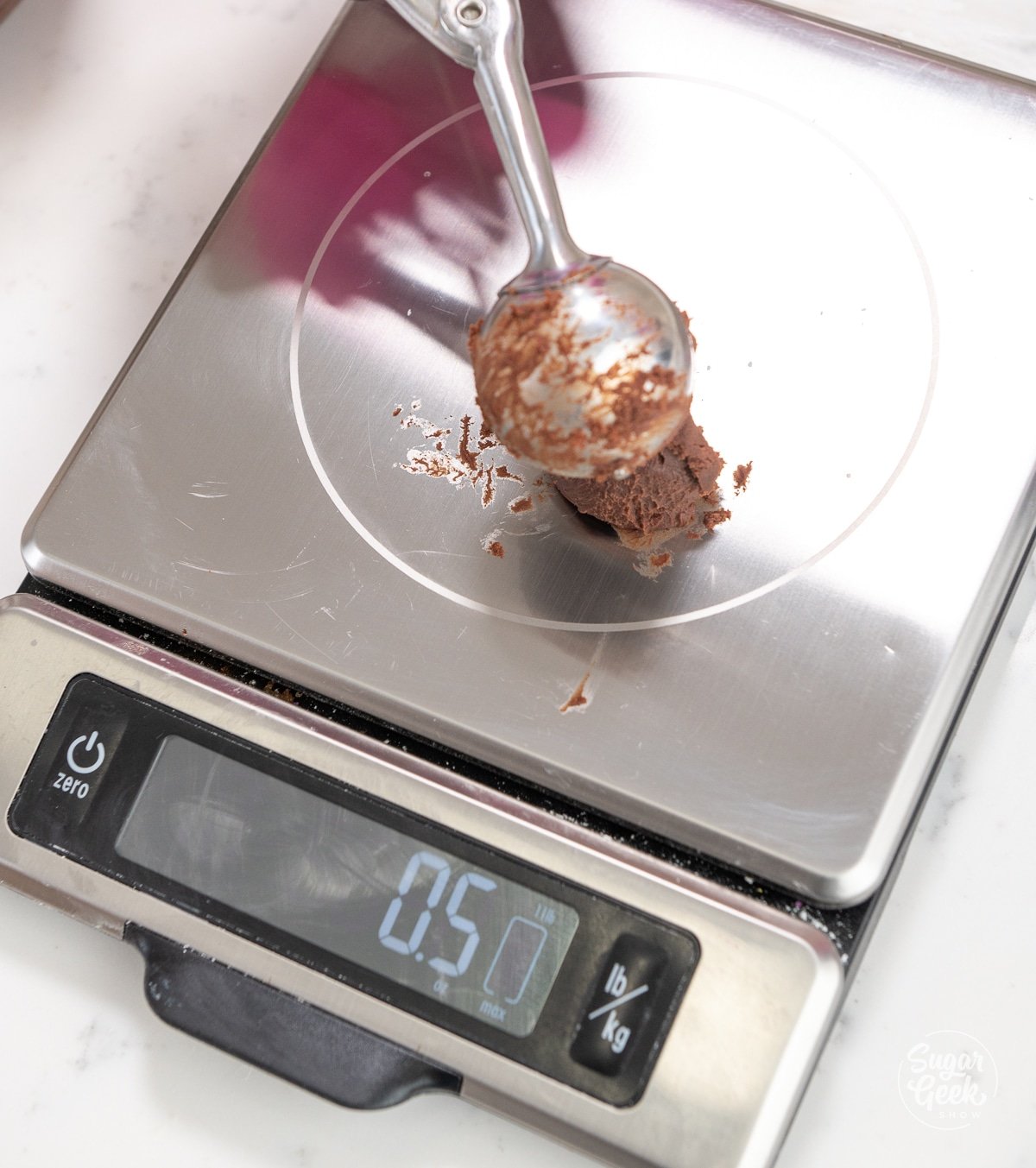 cookie scoop weighing a ball of ganache on a food scale