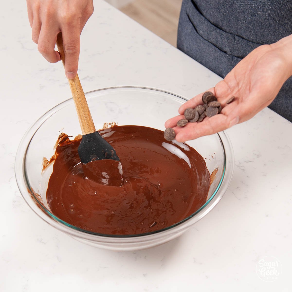 adding tempered chocolate to melted chocolate