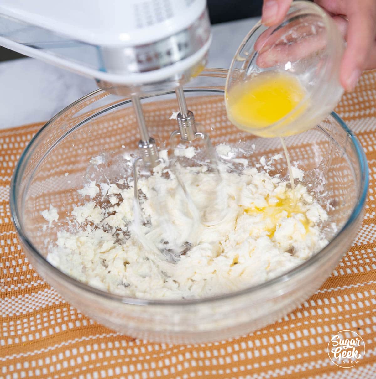 adding melted butter to cream cheese