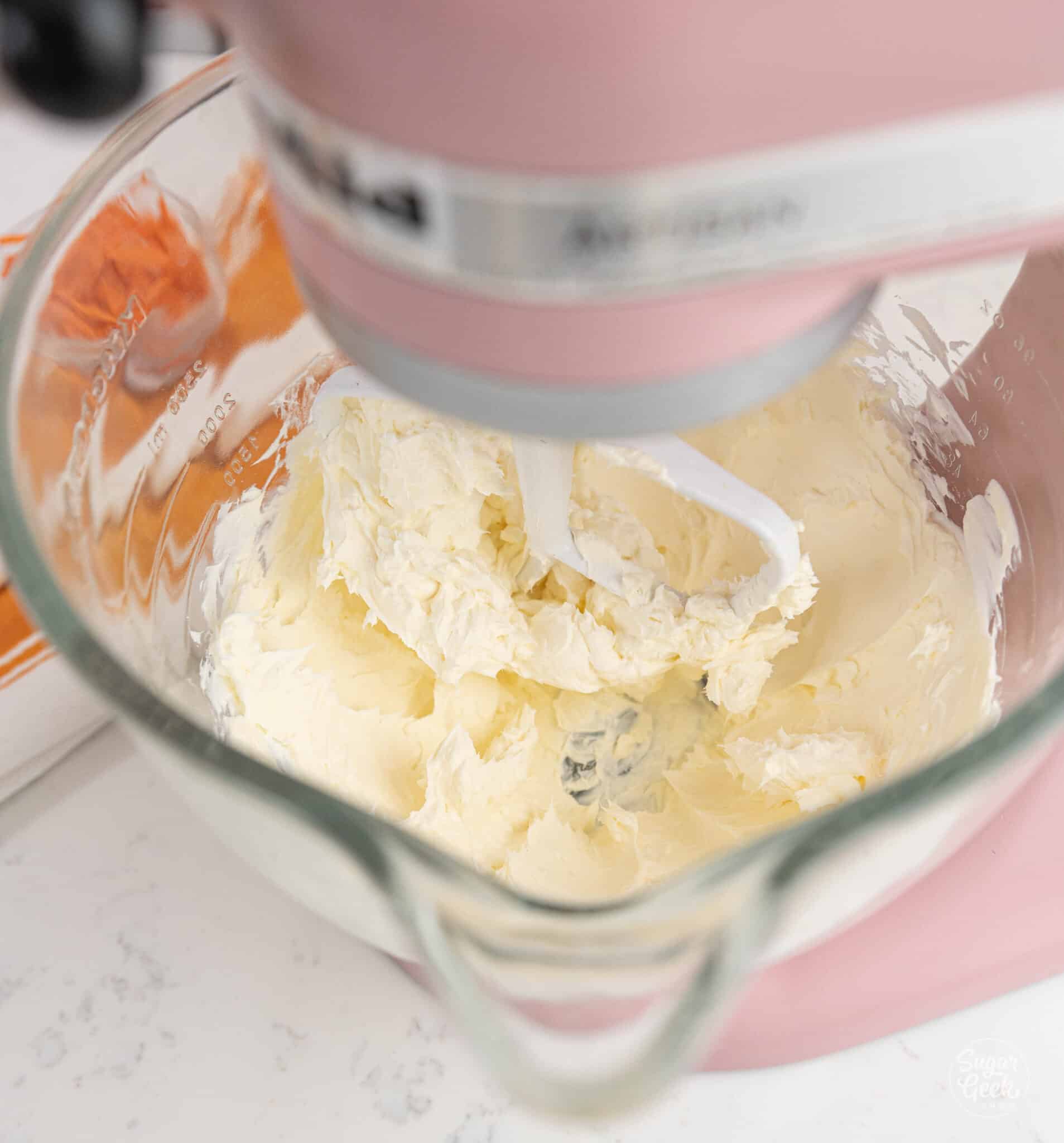 smooth and blended cream cheese in a glass stand mixer bowl