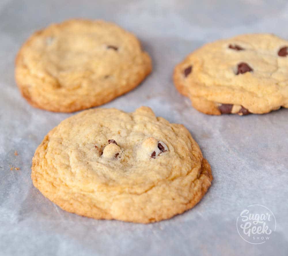 Chocolate chip cookies with extra flour added on a parchment paper lined baking sheet