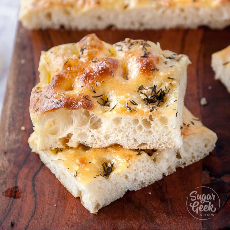 slices of baked focaccia with rosemary and flakey salt stacked on top of each other