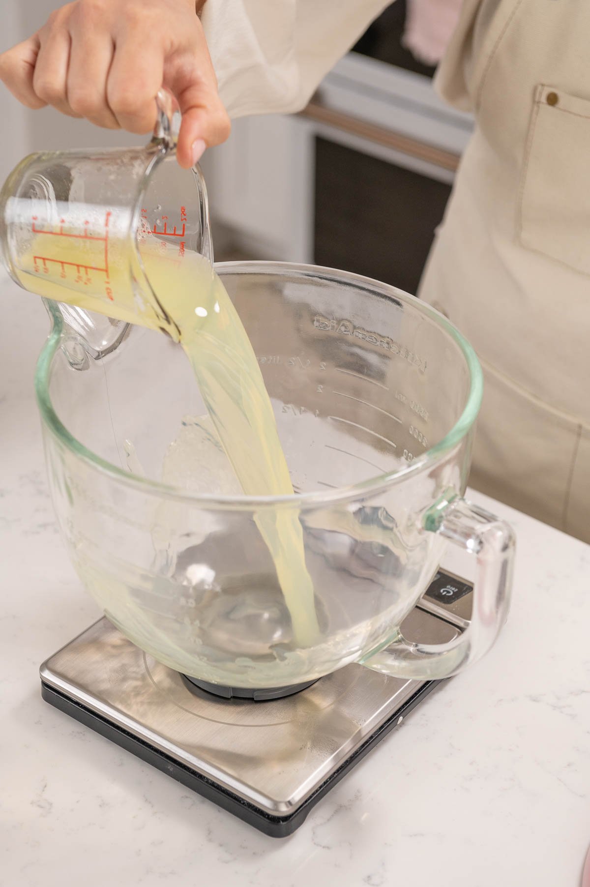 pouring pasteurized egg whites into a glass bowl