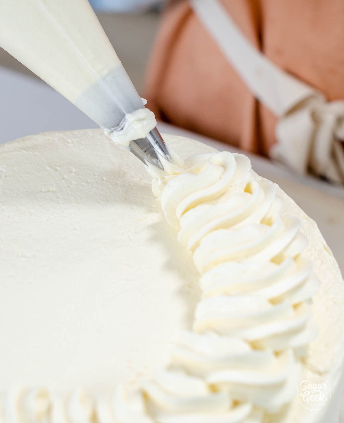 piping a rope border on top of the cake