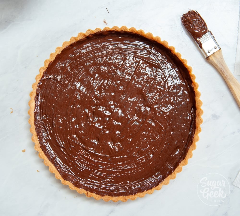 melted chocolate brushed onto a tart shell
