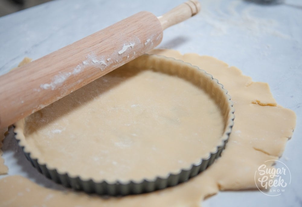 Tart dough in a meal tin with a rolling pin on top