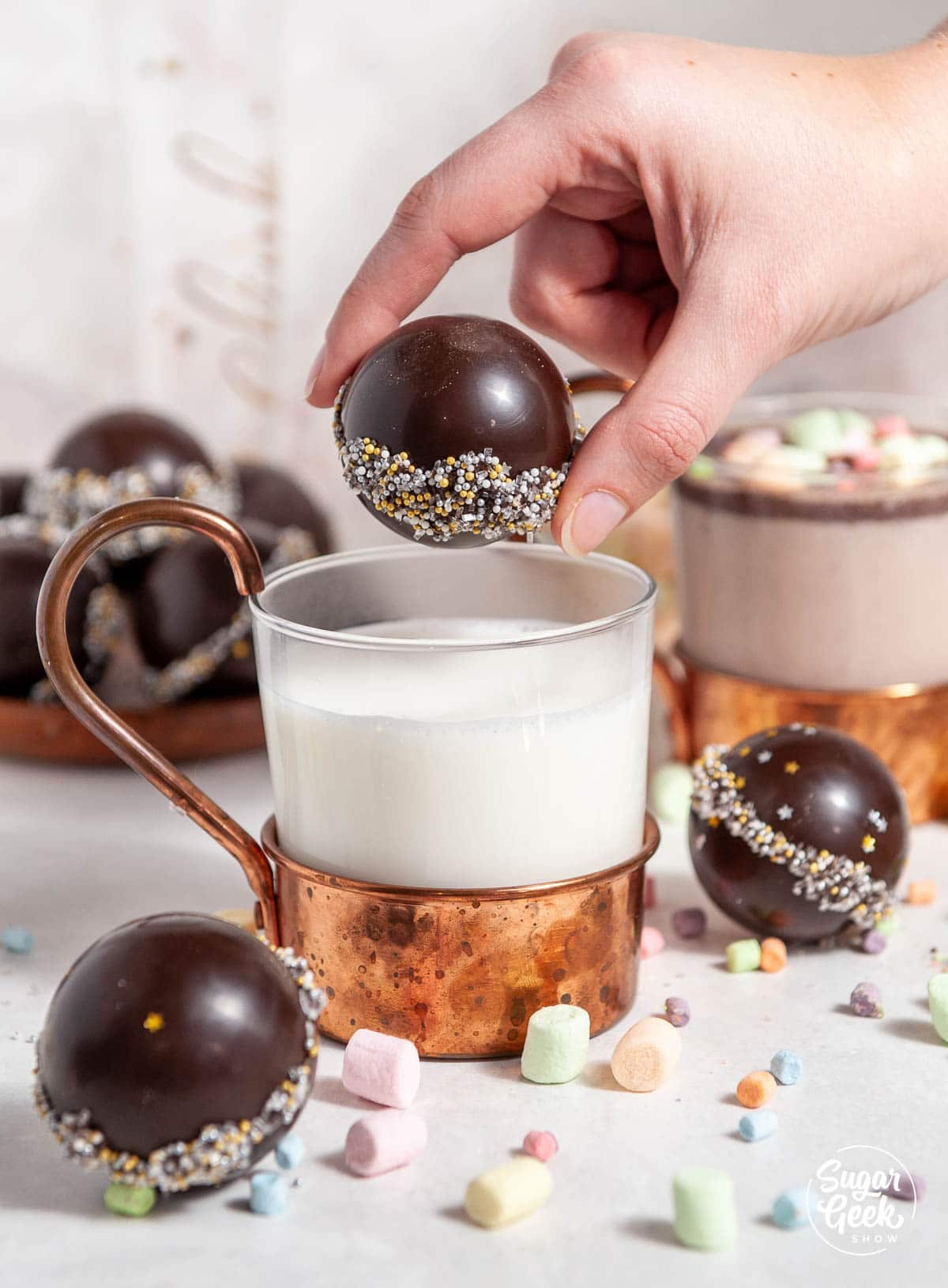 Hot chocolate cocoa bomb dropped into hot milk in copper mug