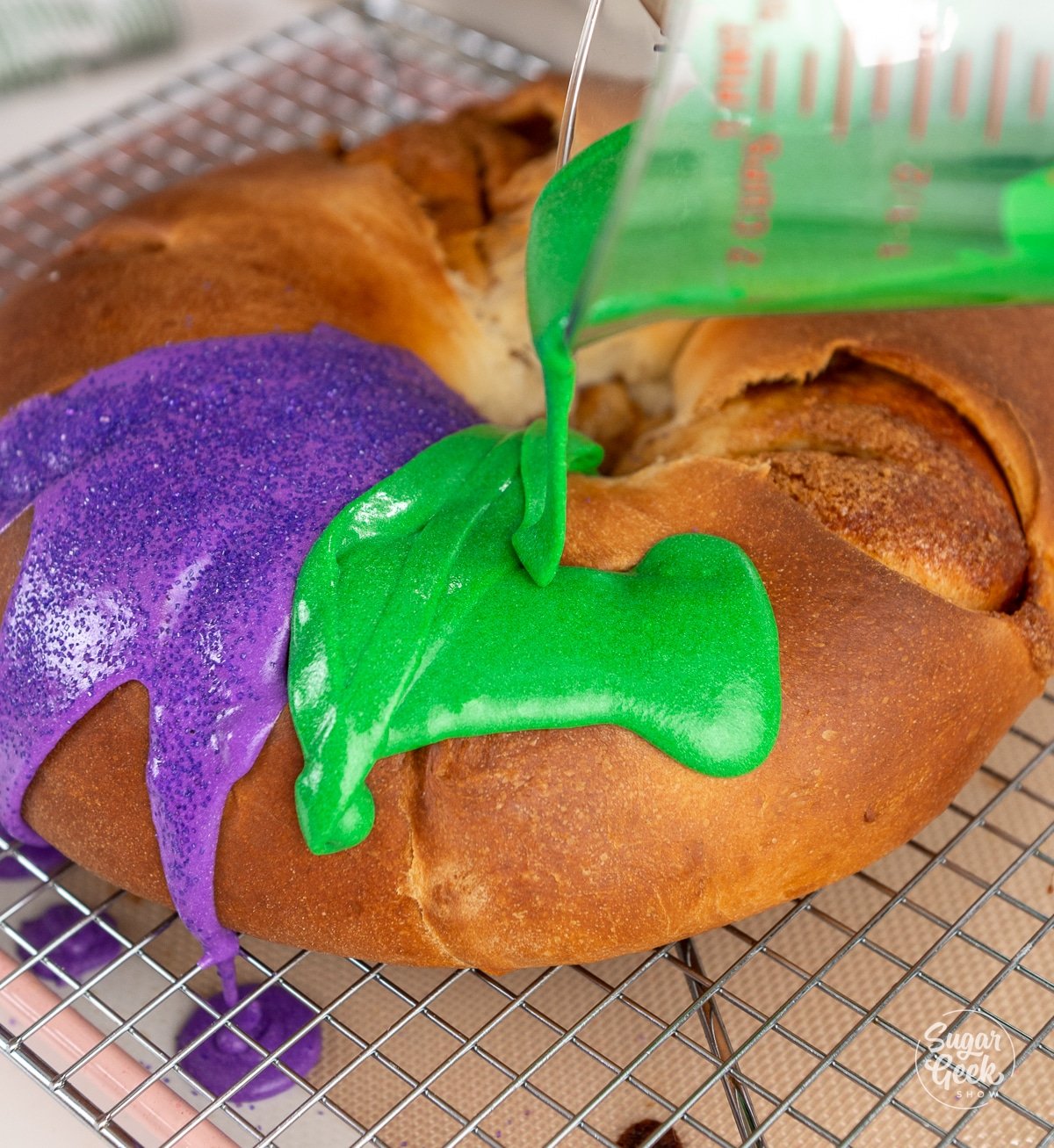 green glaze pouring from a measuring cup onto a king cake