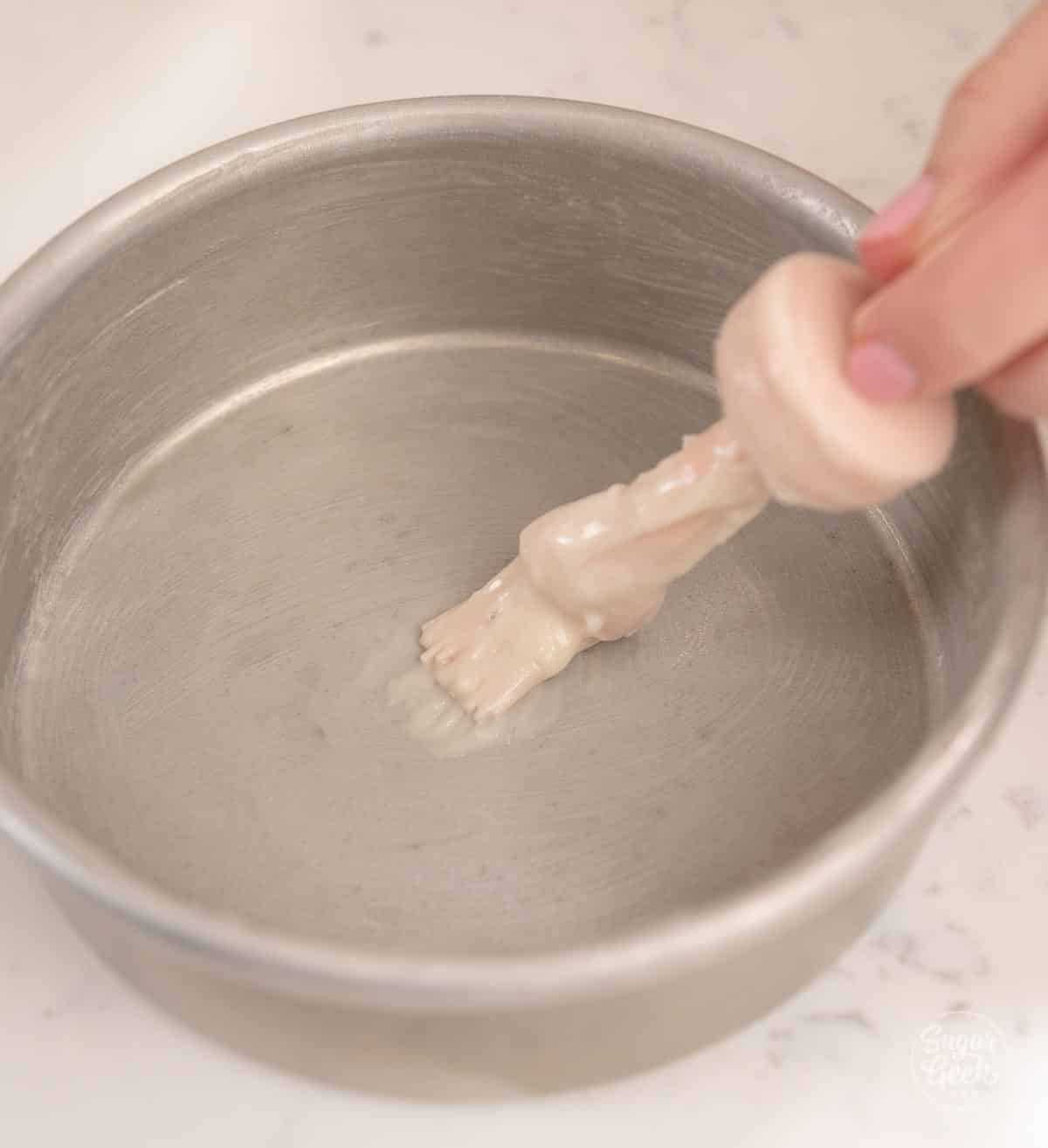 spreading cake goop into a cake pan