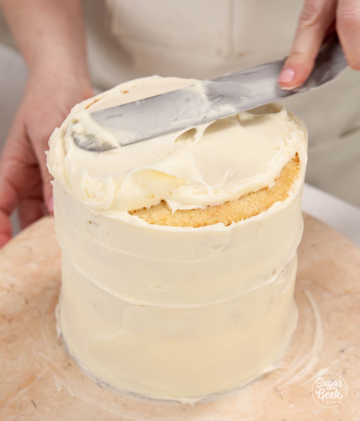 covering the lemon cake in a crumbcoat