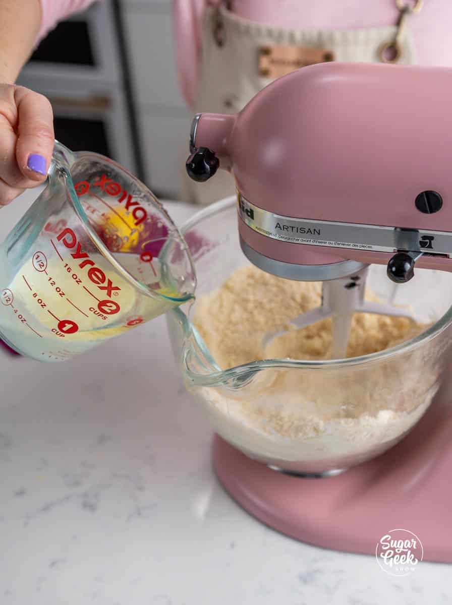 pouring liquid ingredients into a stand mixer bowl