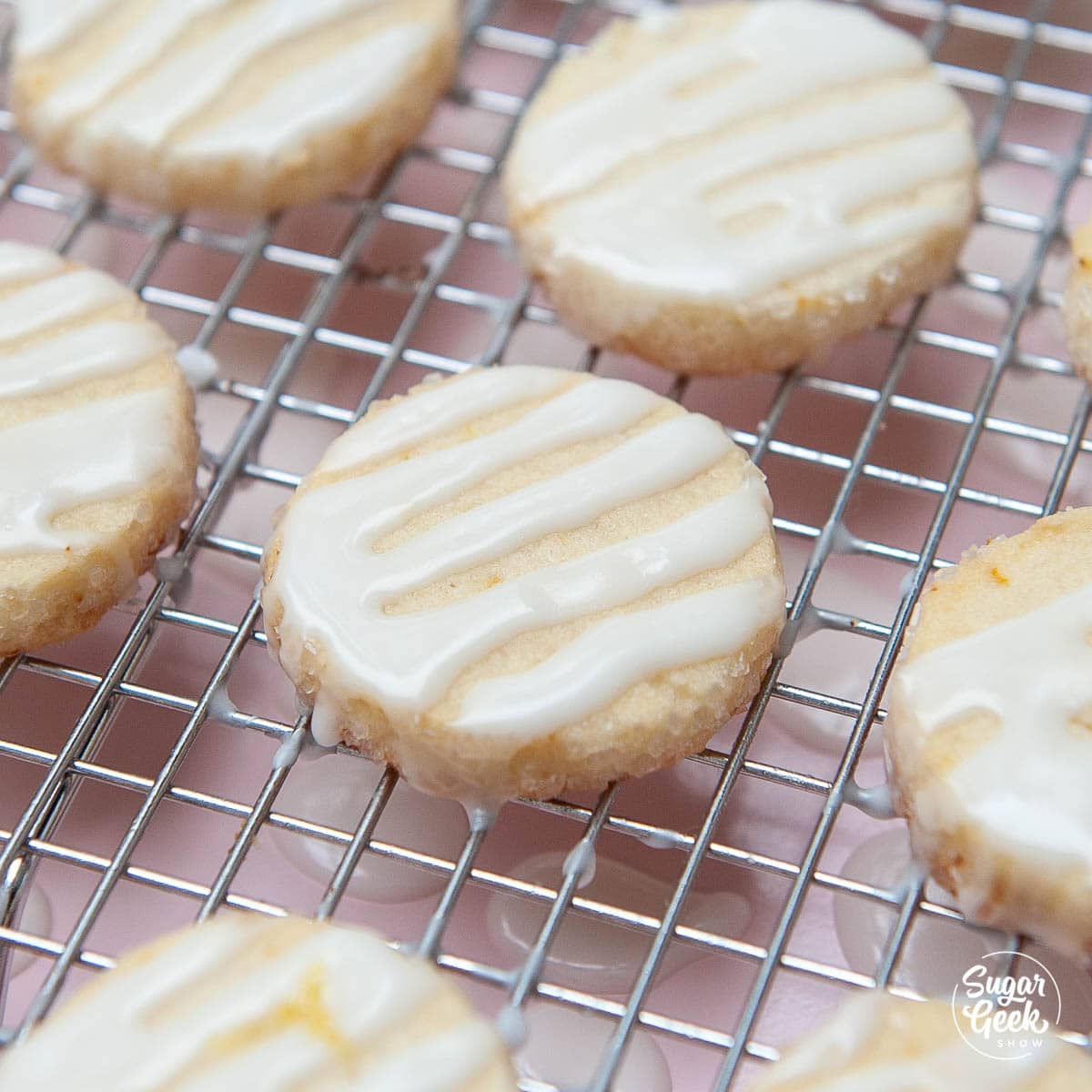 closeup of lemon shortbread cookies with lemon glaze on a cooling rack