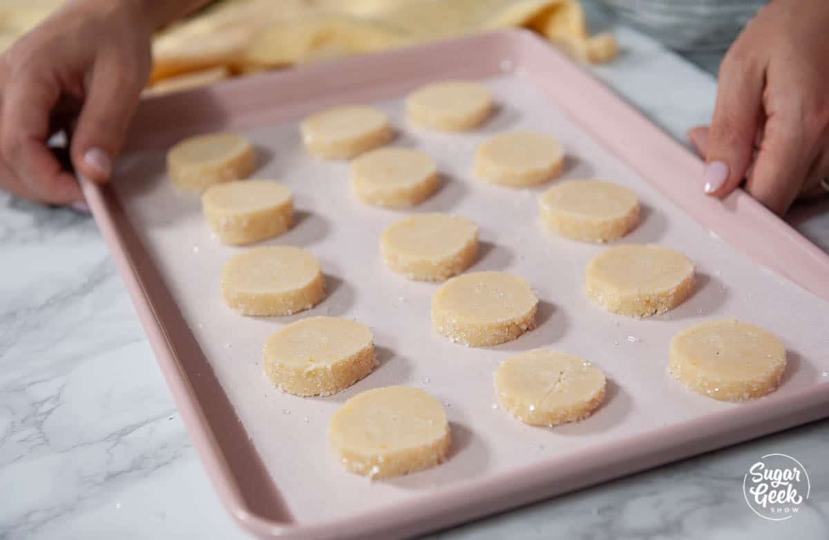 lemon shortbread cookies on a pink cookie sheet with parchment paper