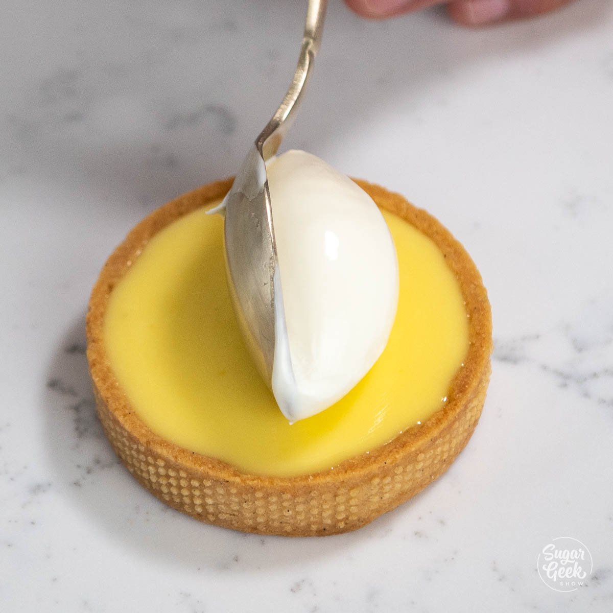 placing a scoop of creme fraiche on lemon tart