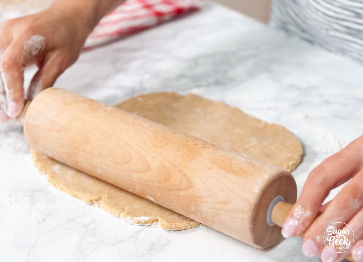 rolling Linzer cookie dough out with a wooden rolling pin