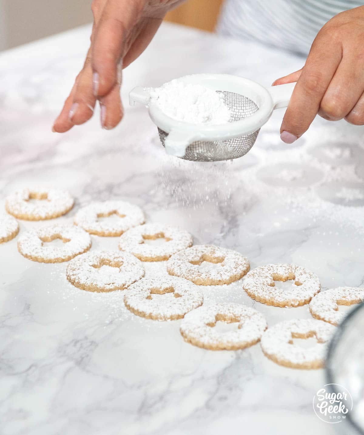 dusting linzer cookies with powdered sugar