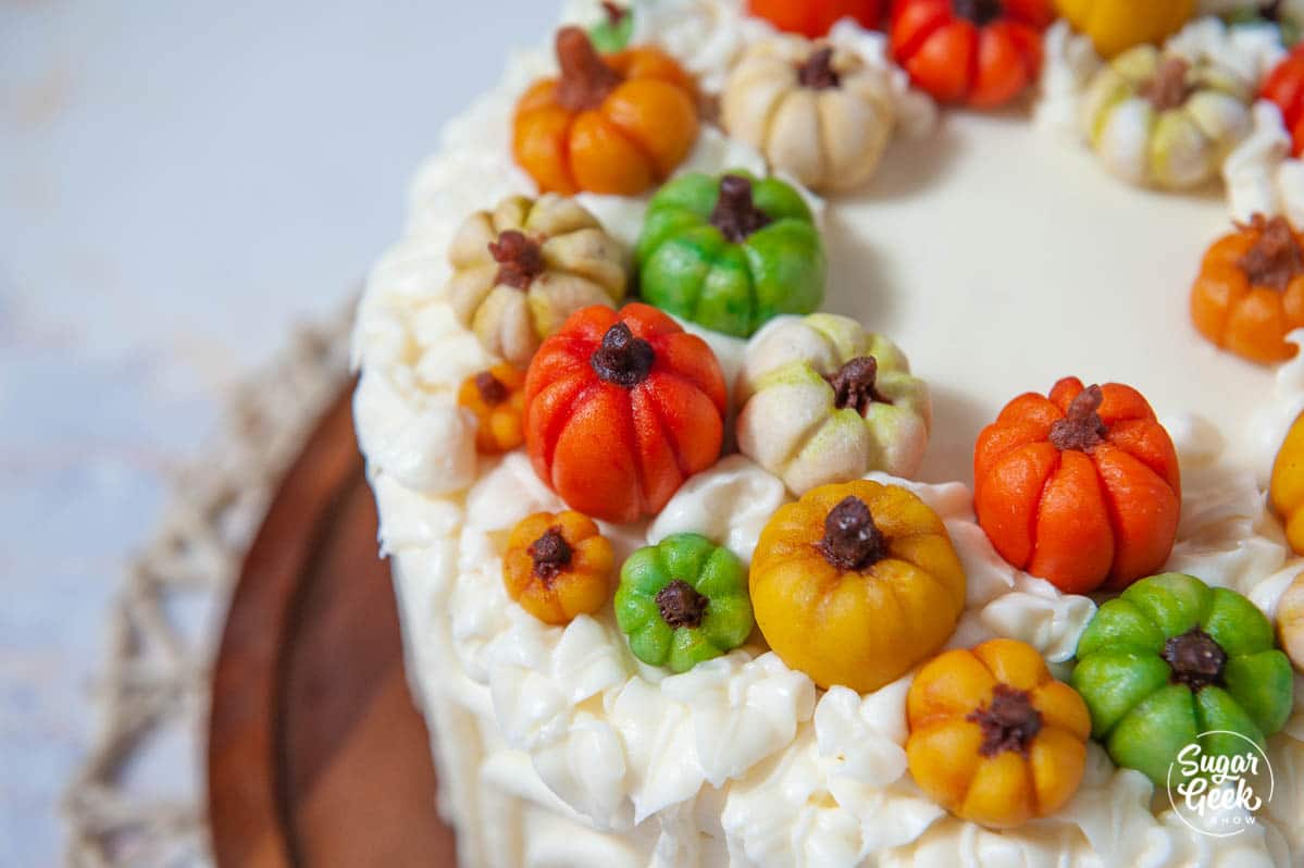 closeup of marzipan candy pumpkins on a cake