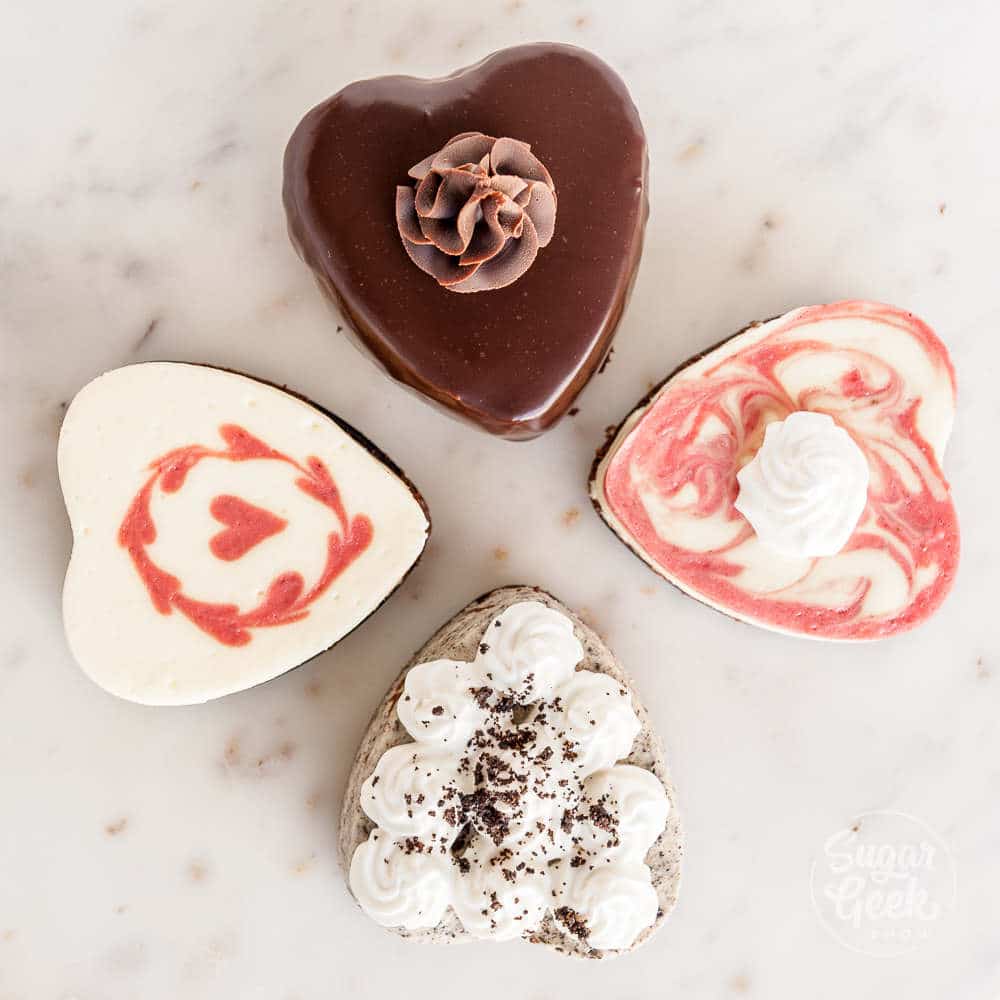 four mini heart cheesecakes on a marble background