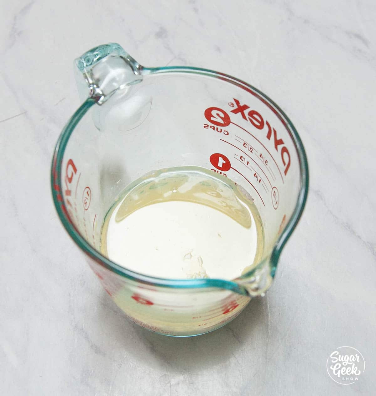 closeup of milk and oil in a measuring cup shot from above