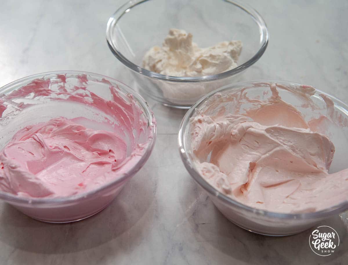 three bowls of pink buttercream frosting
