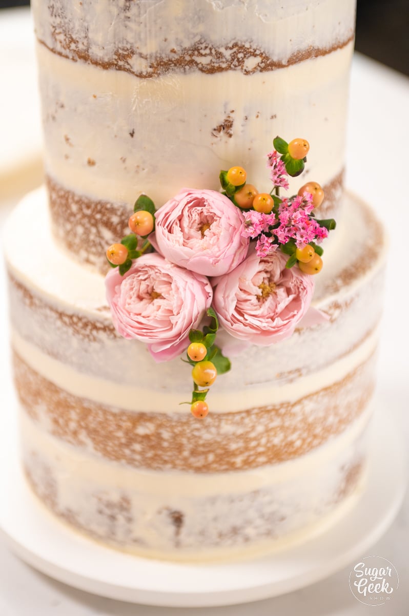 close up of flowers on naked wedding cake