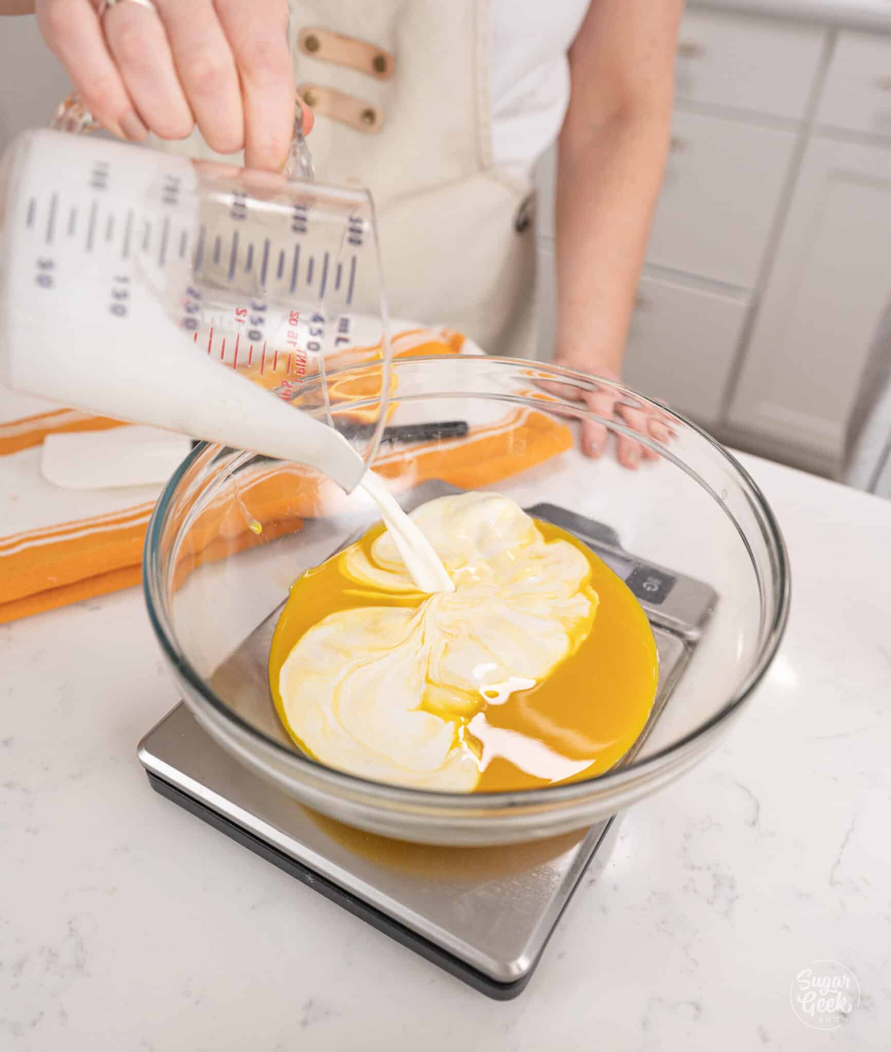 pouring milk into a bowl of orange concentrate