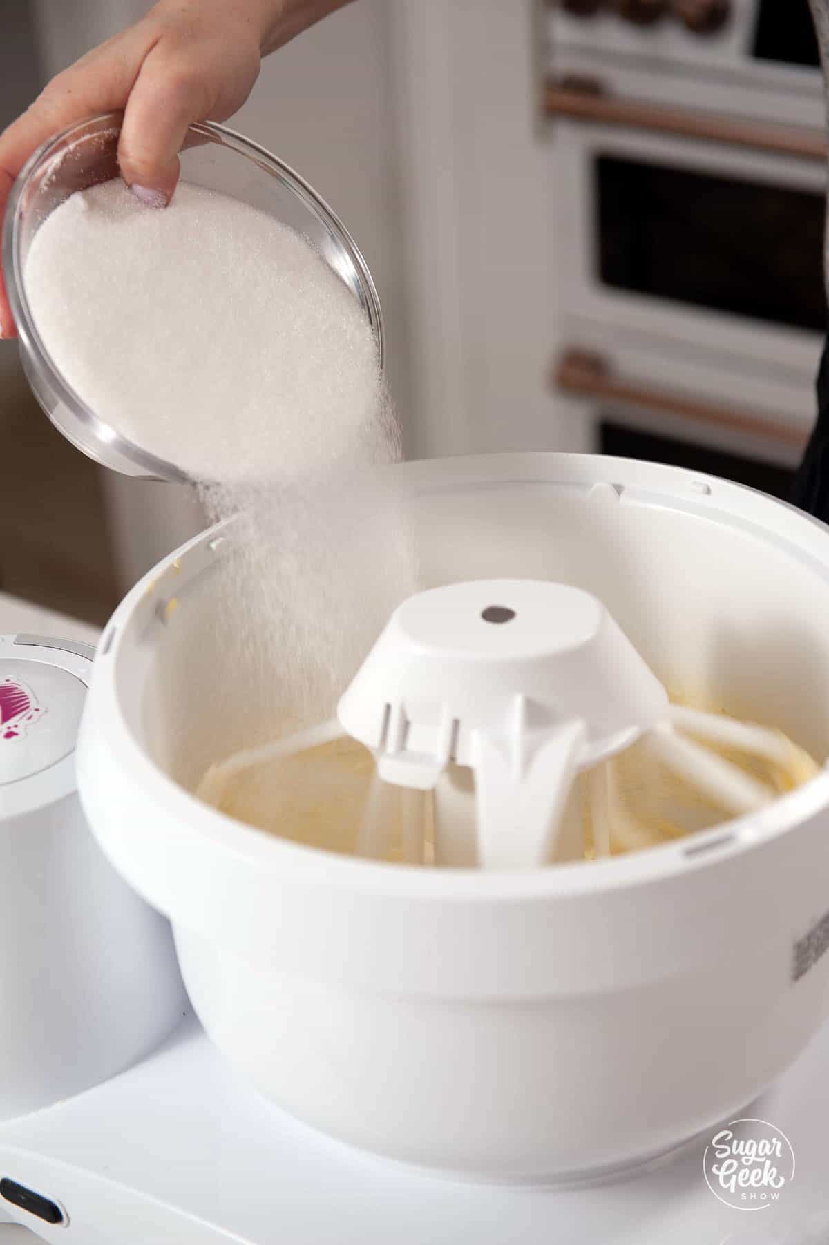 adding sugar to creaming butter in a mixer