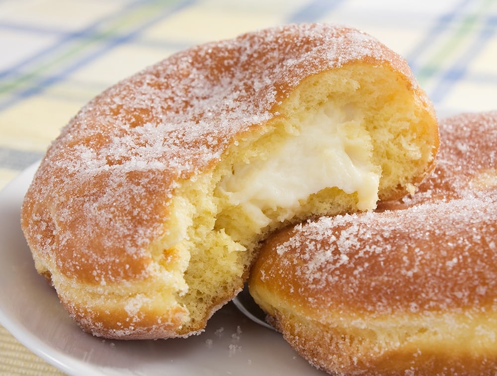 pastry cream filled donut on a white plate