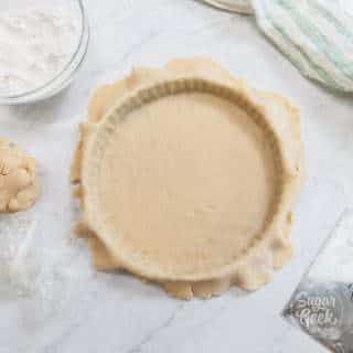 tart dough in tart pan with ingredients around it