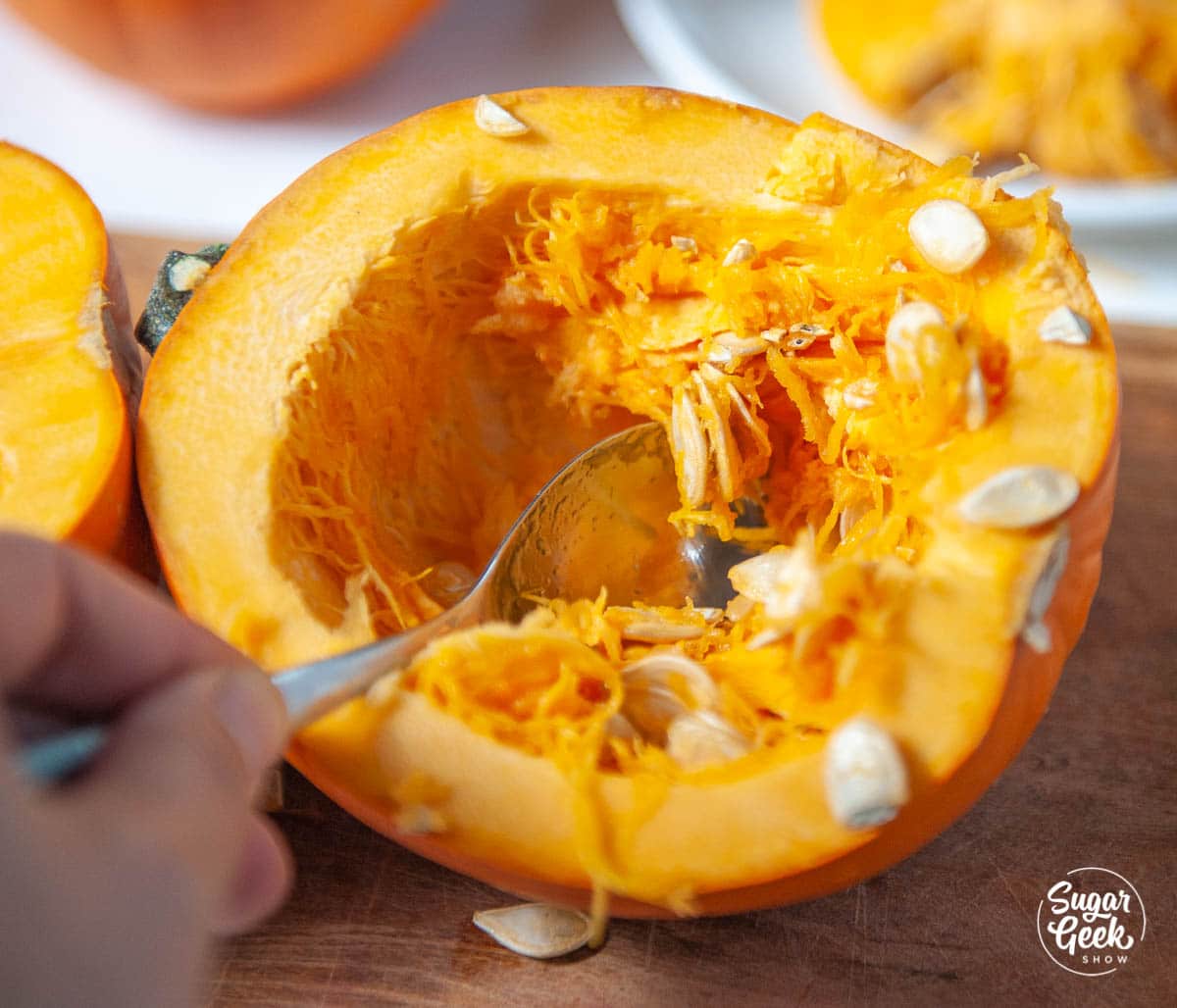 removing pumpkin seeds from a pumpkin with a spoon