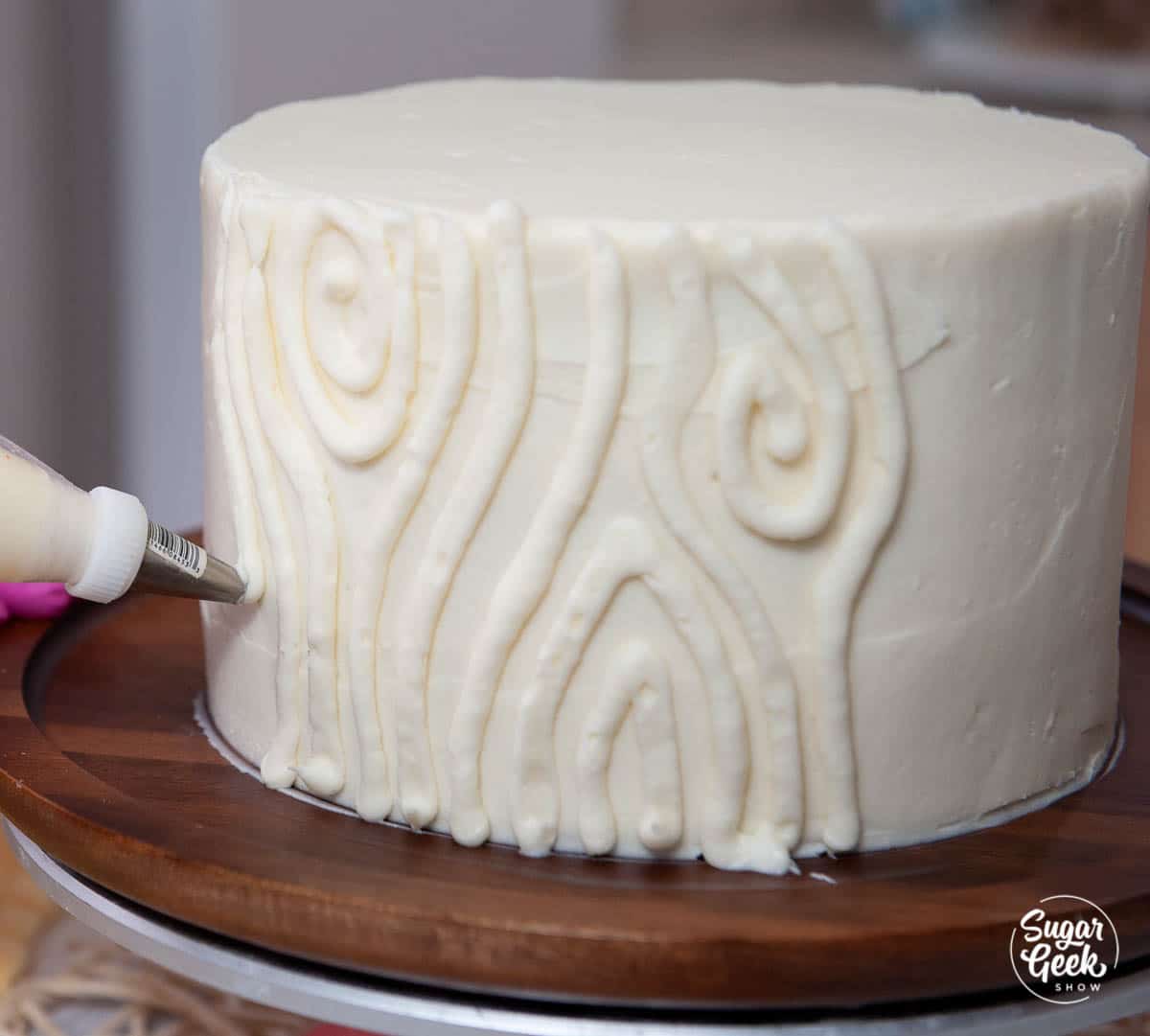 piping a wood grain texture onto the side of a cake
