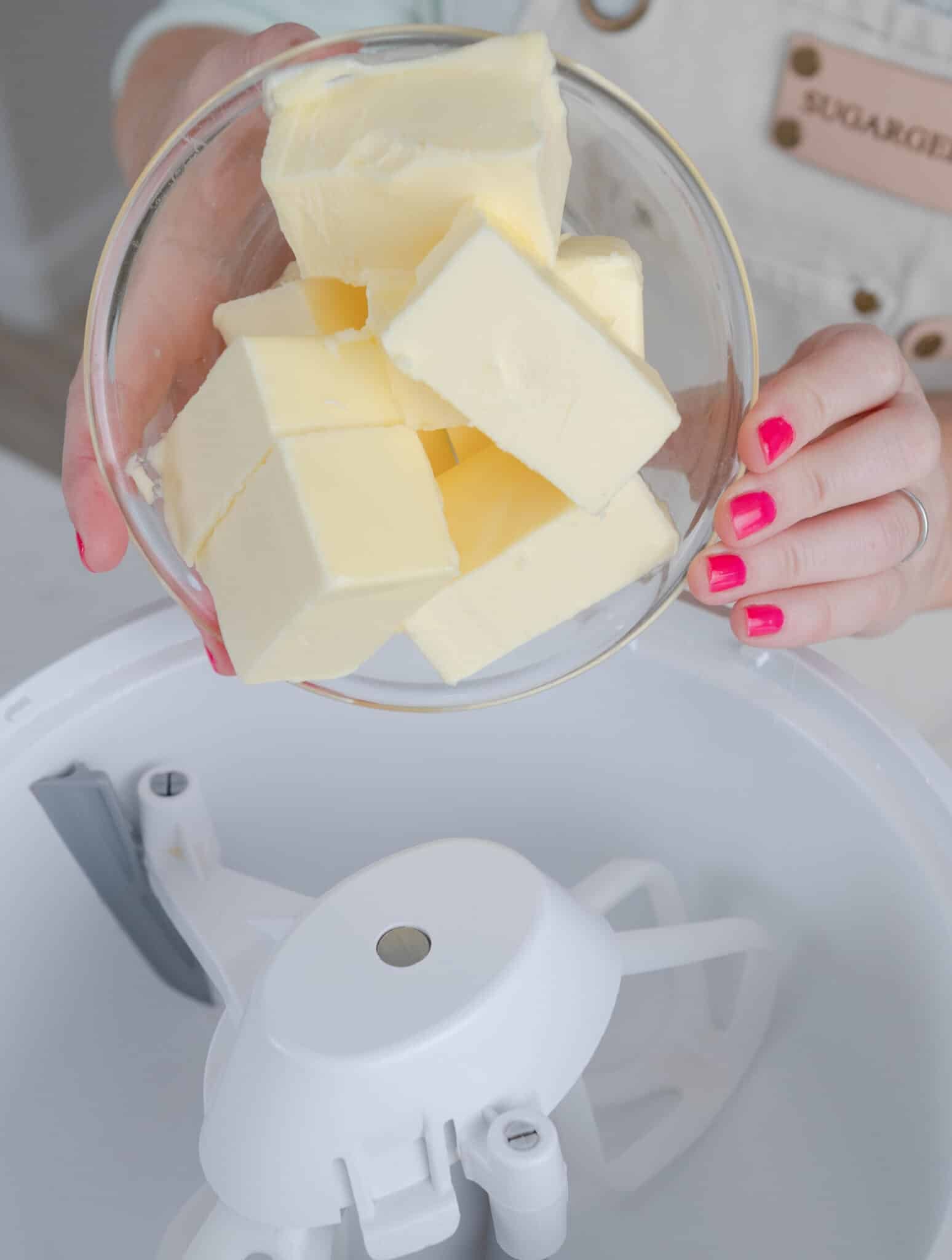 hands adding a bowl of butter into a stand mixer